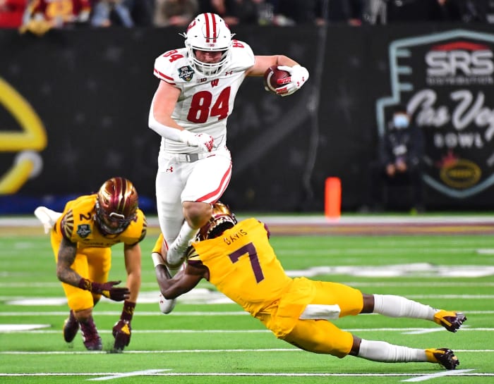 Dec 30, 2021; Paradise, Nevada, USA; Wisconsin Badgers tight end Jake Ferguson (84) attempts to run through the tackle of Arizona State Sun Devils defensive back Timarcus Davis (7) after evading Arizona State Sun Devils defensive back DeAndre Pierce (2) during the 2021 Las Vegas Bowl at Allegiant Stadium.